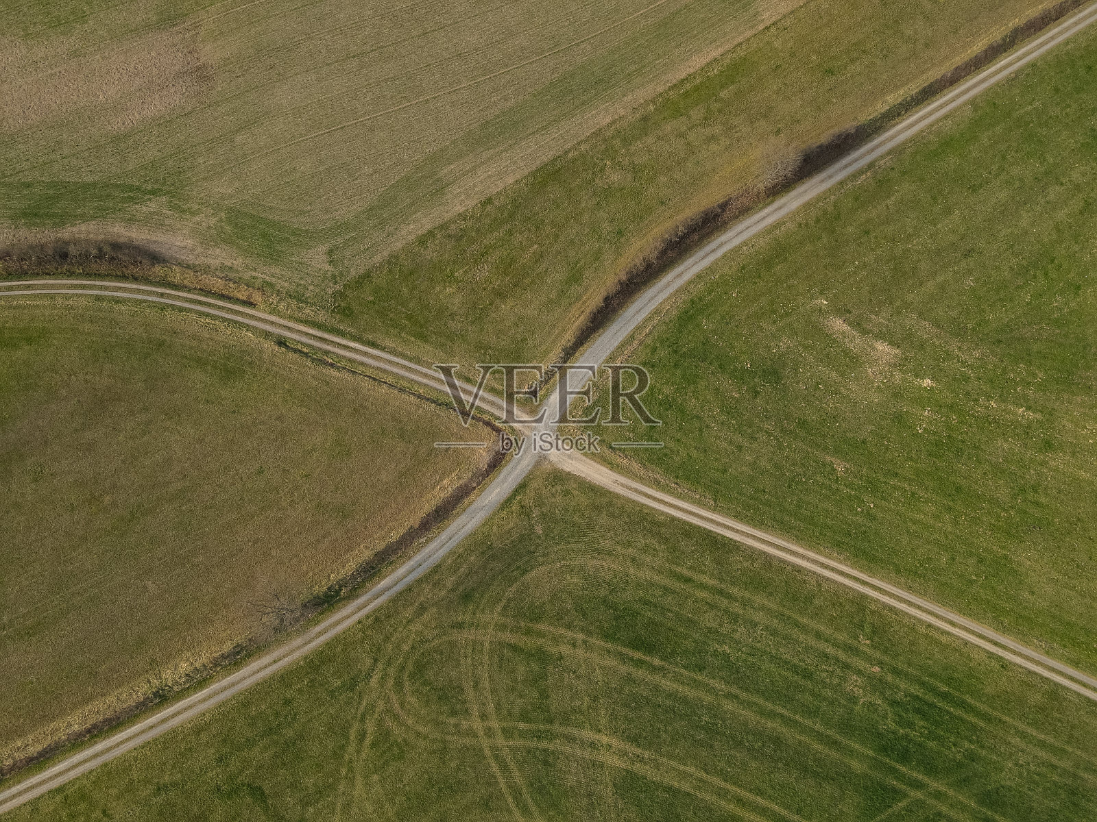鸟瞰春天田野里的一条土路照片摄影图片