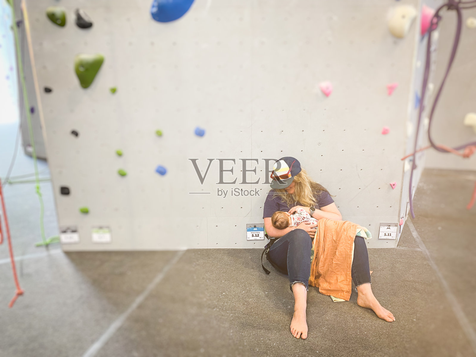 母亲在攀岩馆里给女儿哺乳照片摄影图片