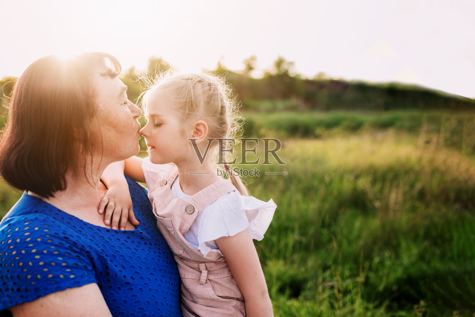祖母抱着孙女，亲吻着她的鼻子照片摄影图片