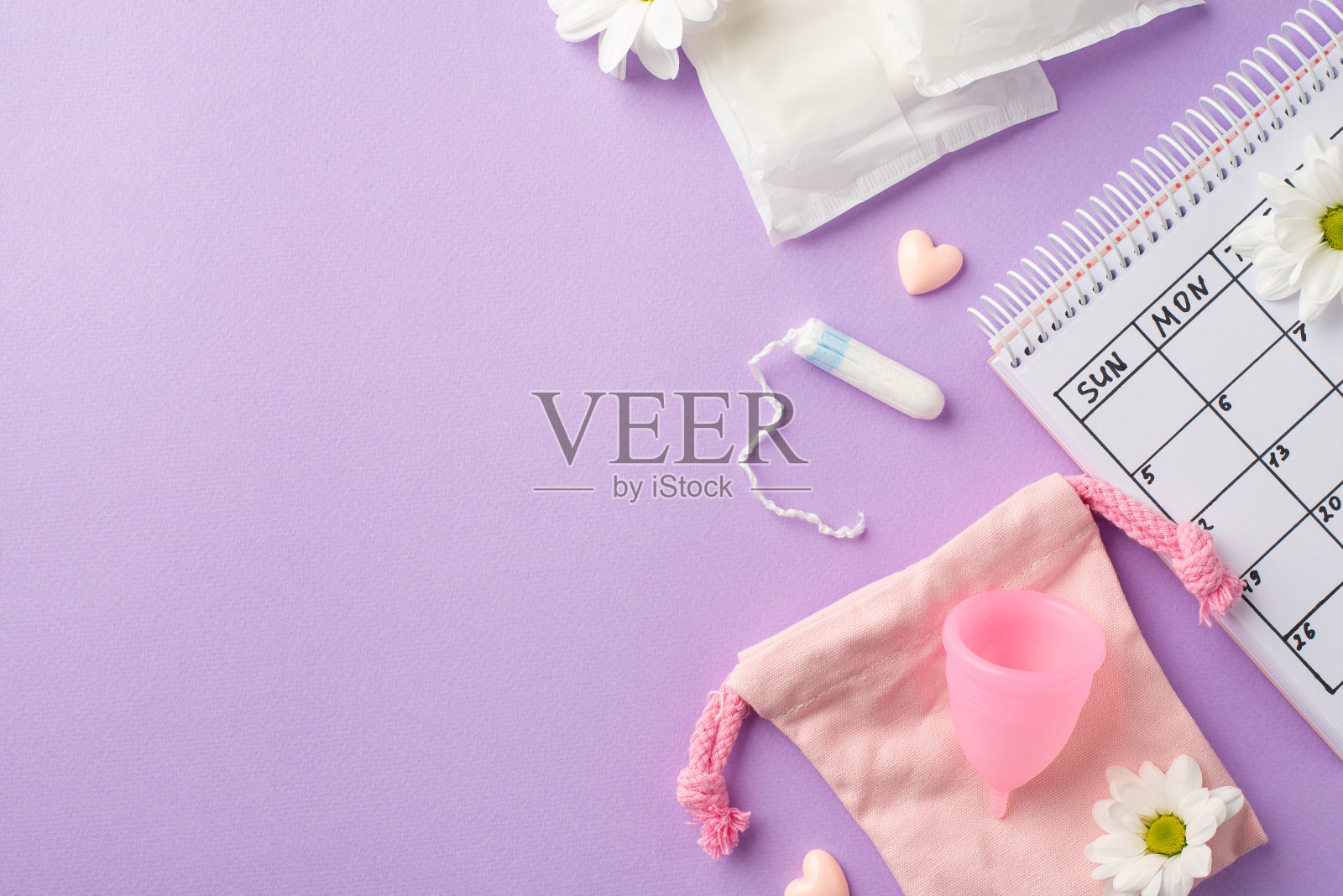 俯视图照片的日历粉红色期间垫袋卫生巾月经杯卫生棉条洋甘菊芽和小心孤立粉彩淡紫色背景与空的空间照片摄影图片