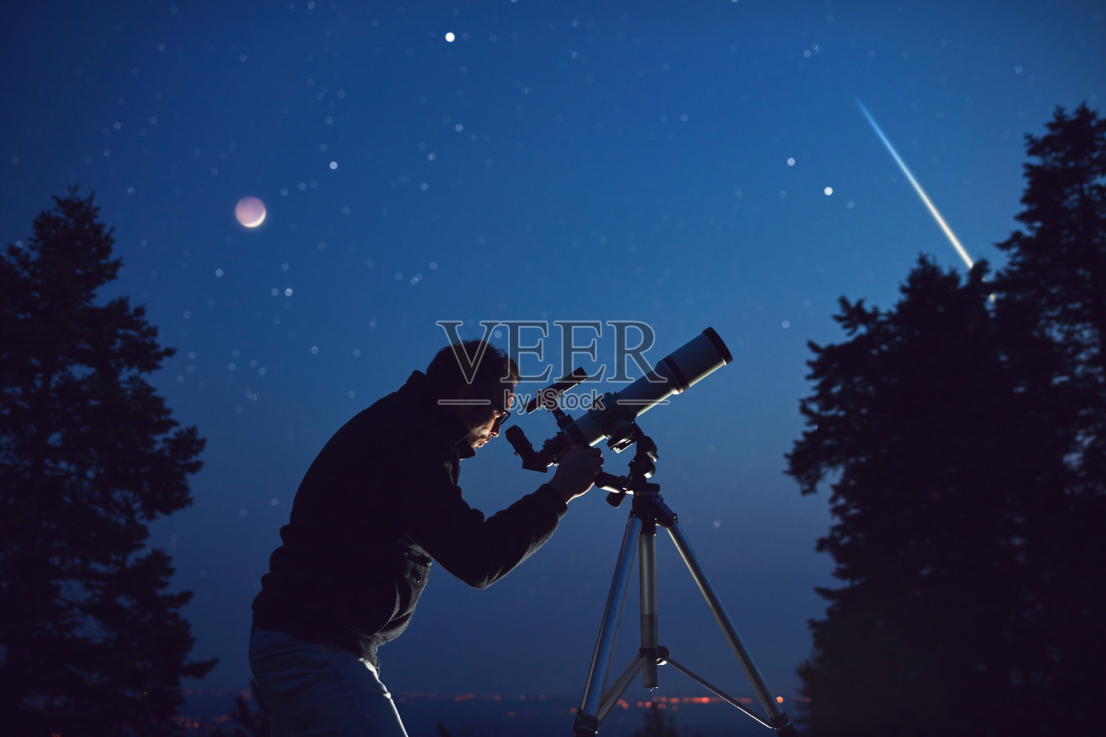 一个人的剪影，望远镜，星星，行星和夜空下的流星。照片摄影图片