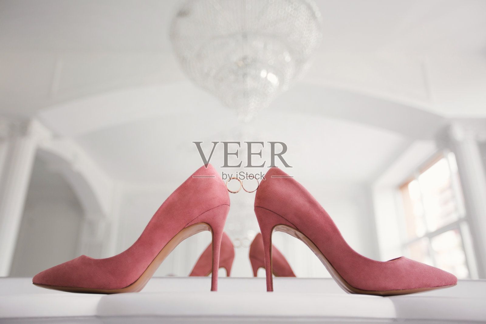 新娘婚礼鞋上的金婚戒。照片摄影图片