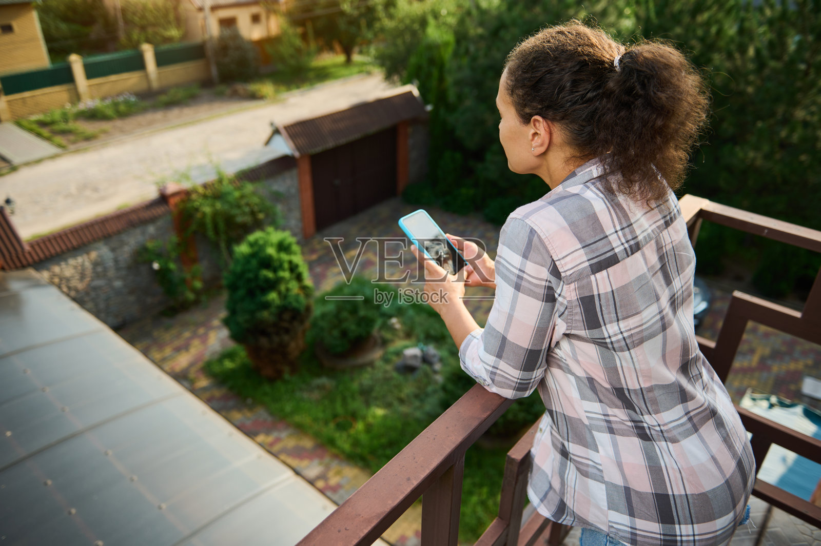 年轻女人在私人别墅阳台玩手机照片摄影图片