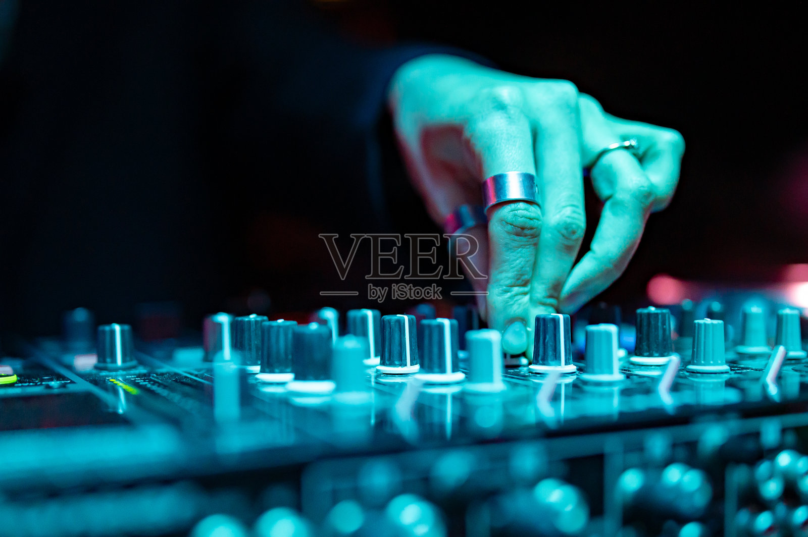 女DJ手创造和调节音乐的DJ控制台混音器在音乐会照片摄影图片