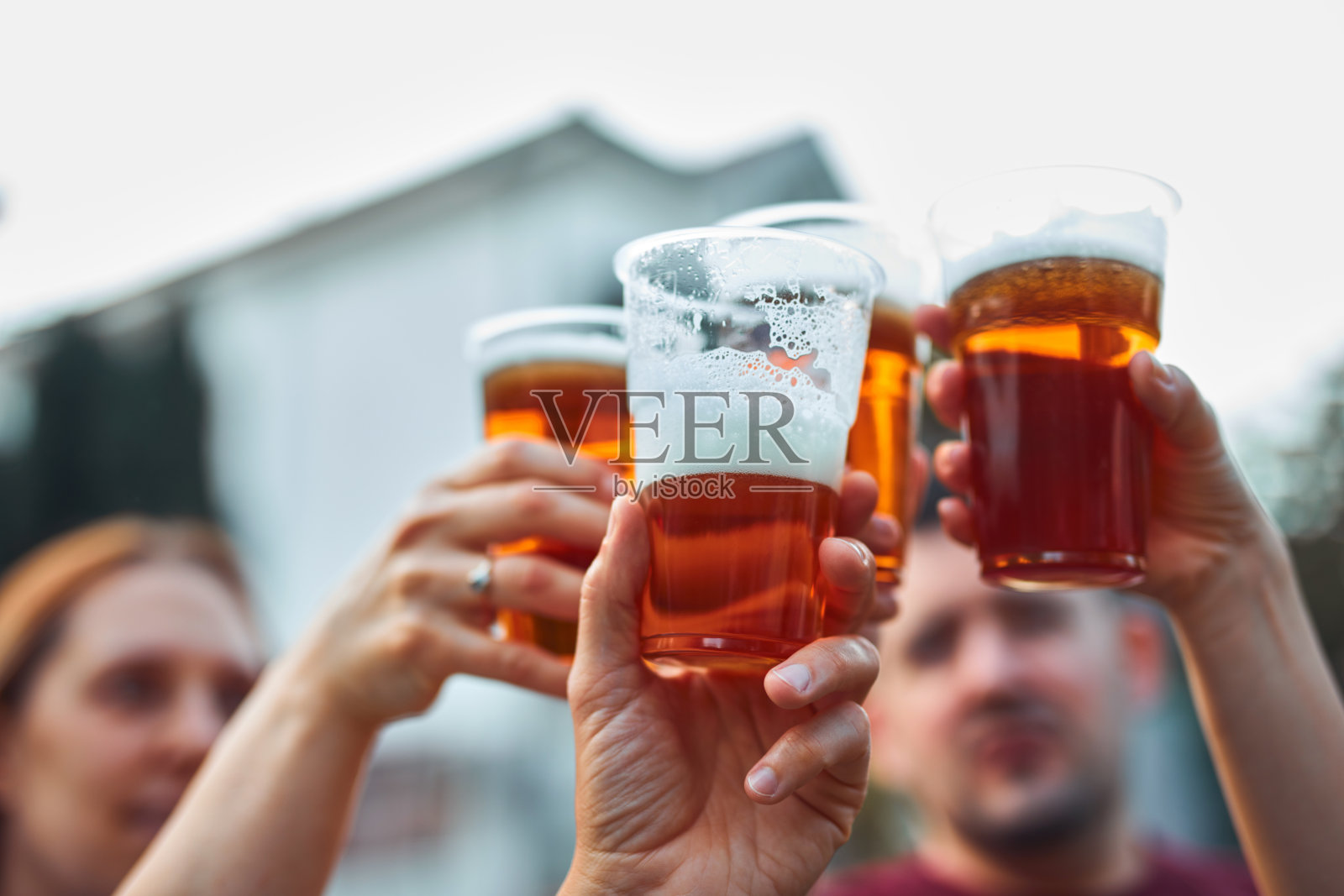 一群朋友在后院聚会上享用冰镇啤酒。照片摄影图片