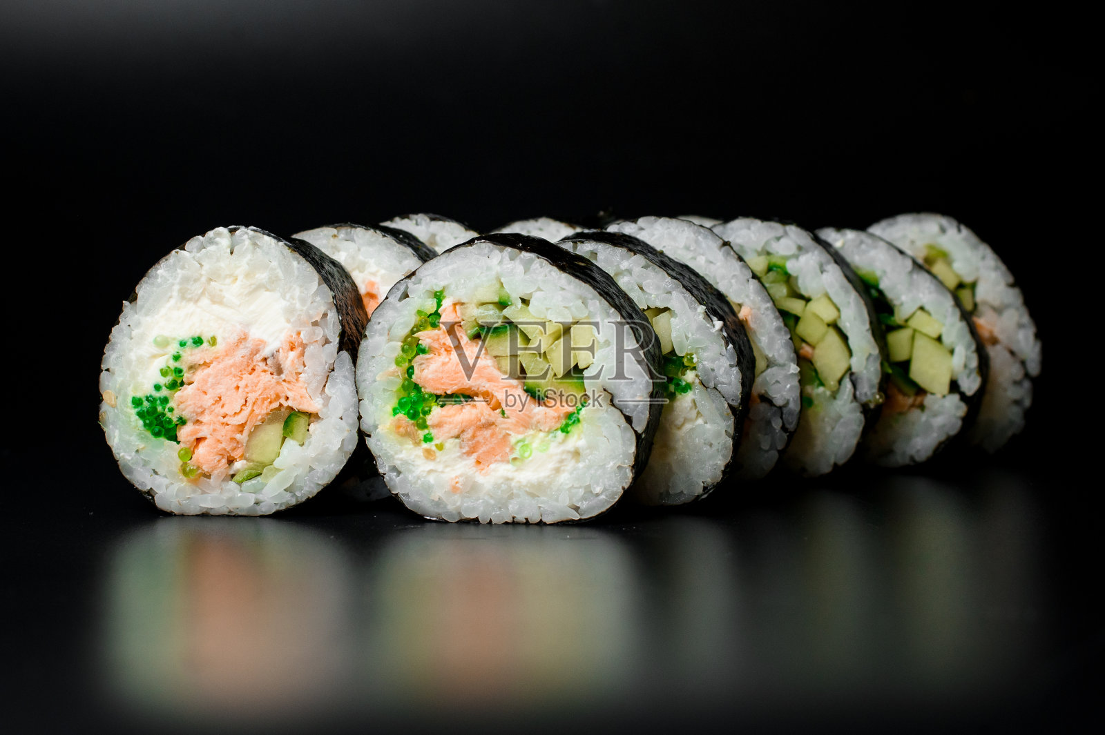 寿司卷有金枪鱼，奶油奶酪，黄瓜，米饭和海苔，单独在黑色照片摄影图片
