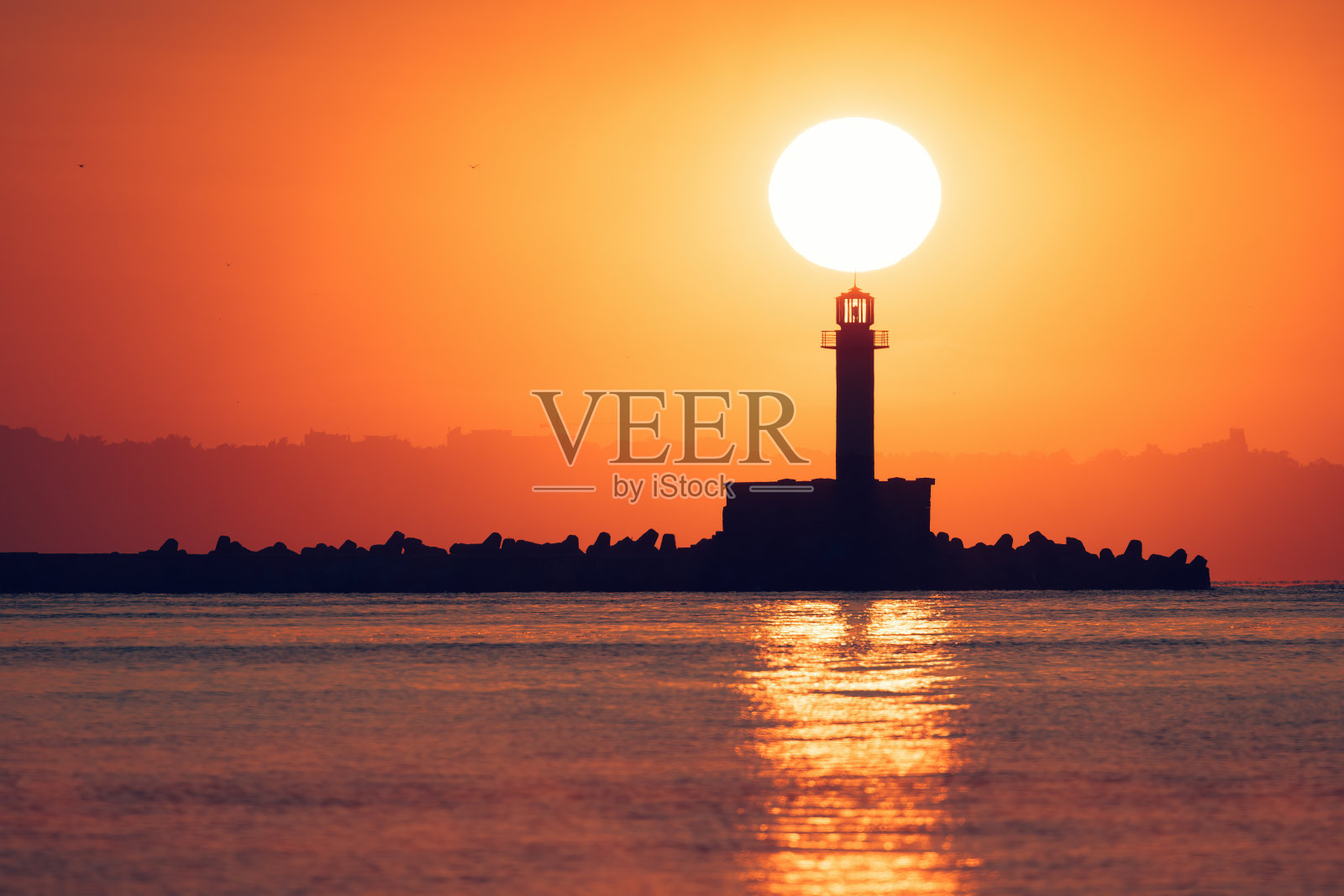 海上灯塔和海岸海滩的日出海景照片摄影图片