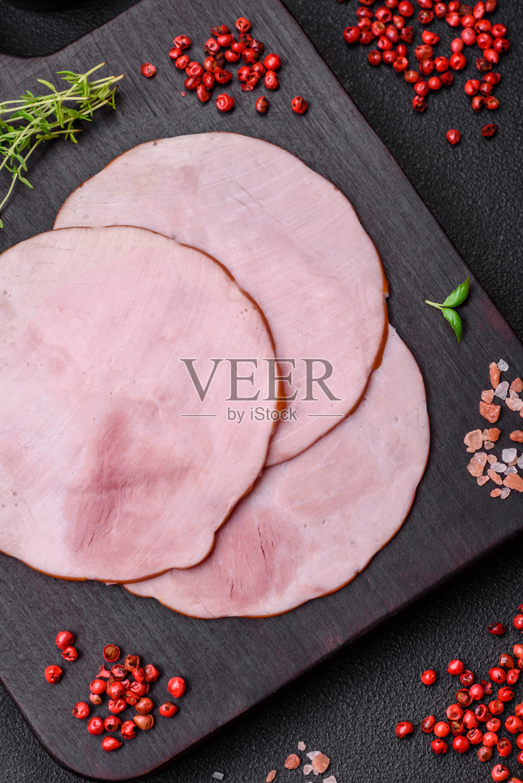 美味的新鲜火腿切成圆片，加入盐、香料和香草照片摄影图片