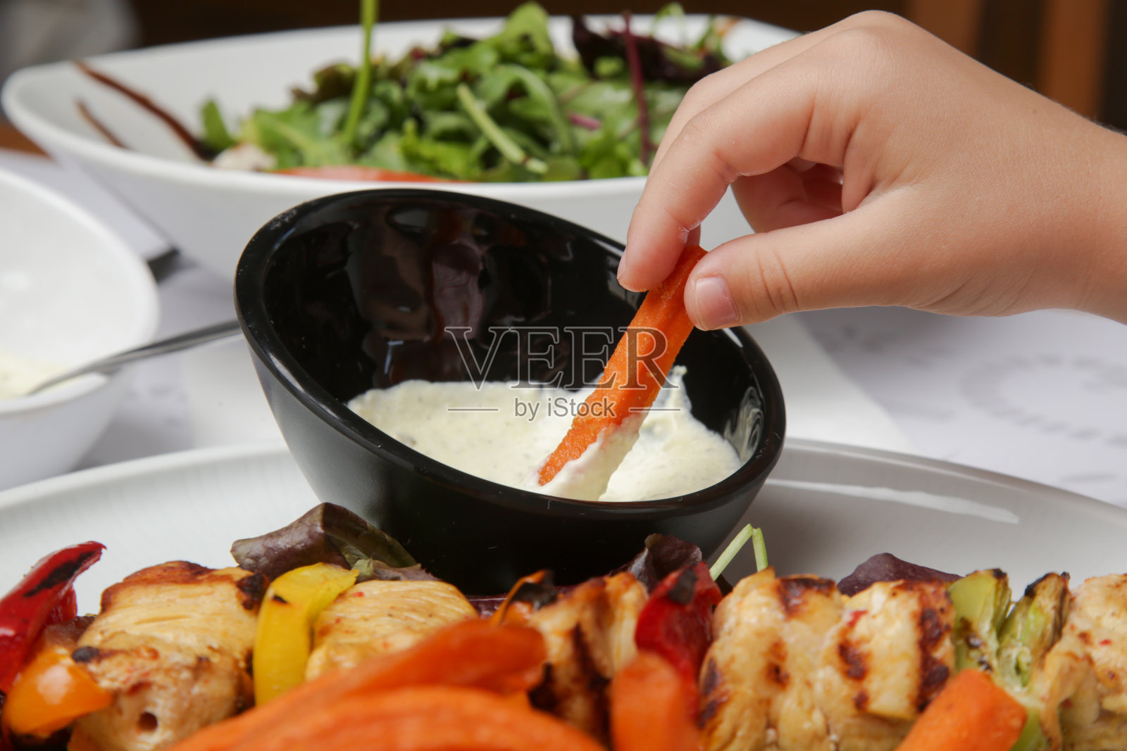 希腊羊肉串，甘薯和酸奶酸奶蘸料在餐厅的盘子上照片摄影图片