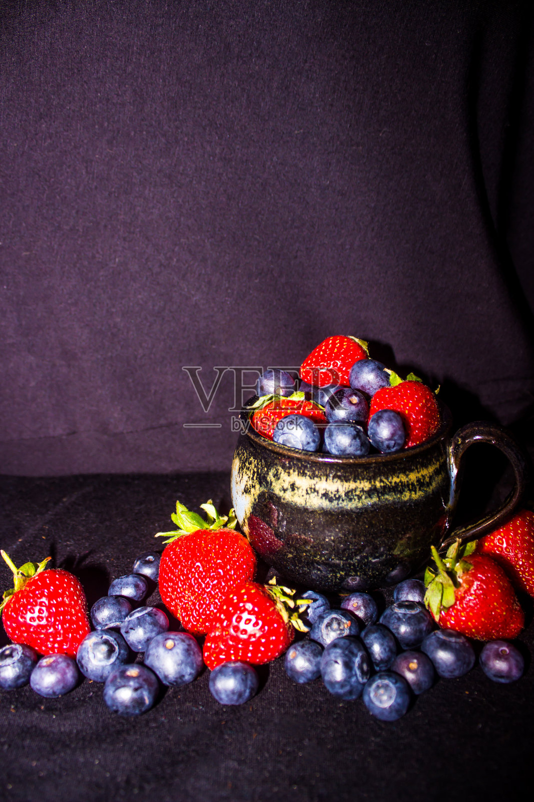 茶杯里装满了草莓和蓝莓照片摄影图片