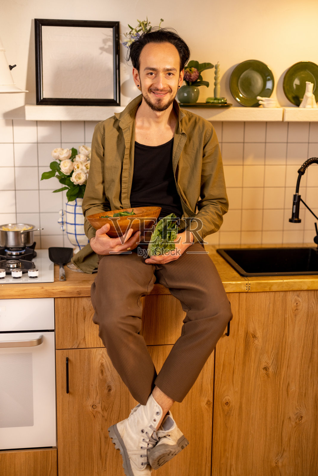 在漂亮的厨房里吃沙拉的男人照片摄影图片