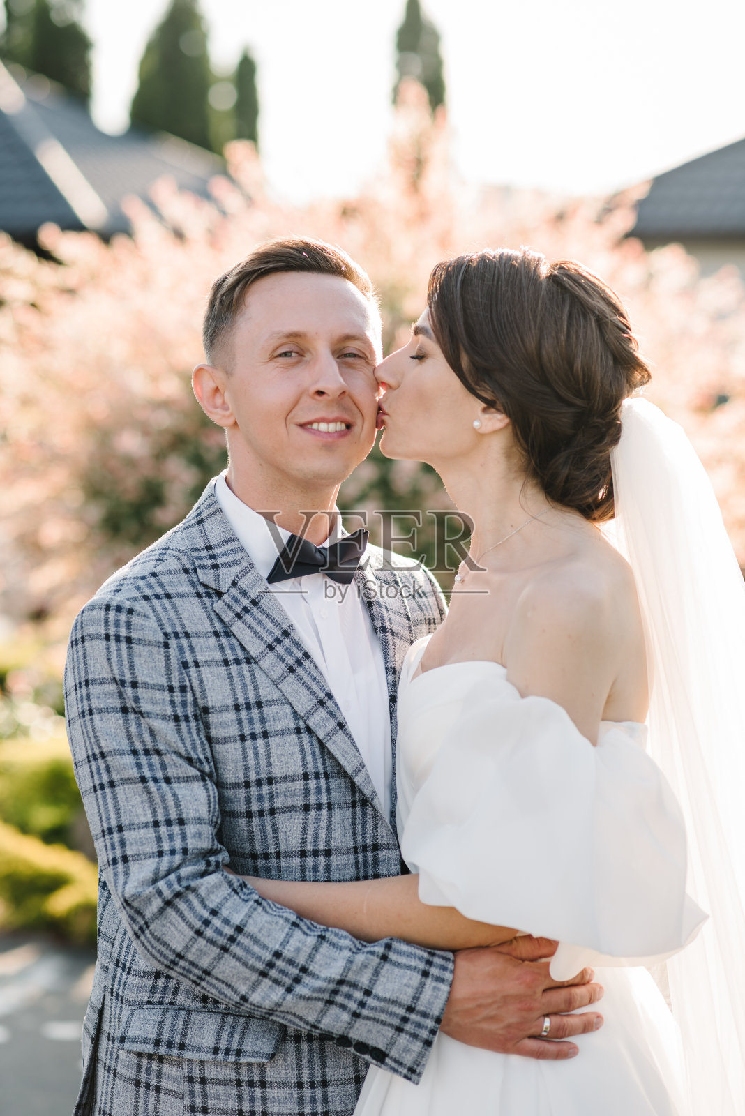 新娘和新郎在大自然中拥抱亲吻。爱情故事。新婚快乐。在户外结婚。新婚夫妇在后院的宴会厅举行婚礼。特写镜头。照片摄影图片