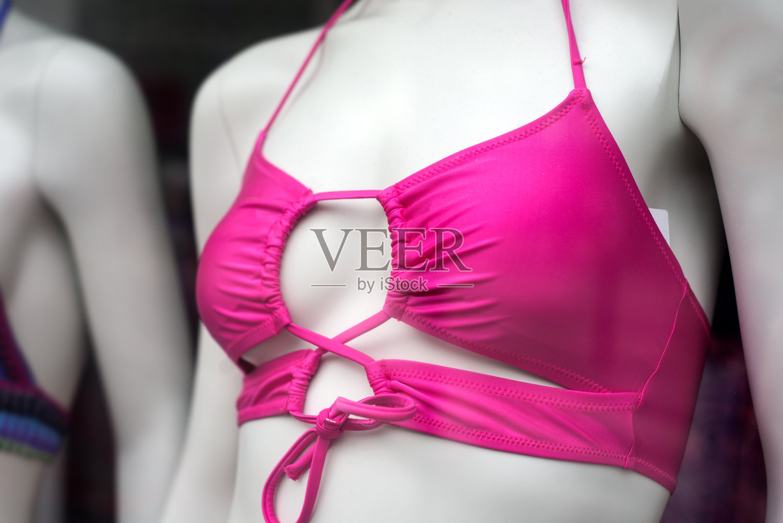 时装店陈列室里，模特身上的粉色比基尼胸罩照片摄影图片