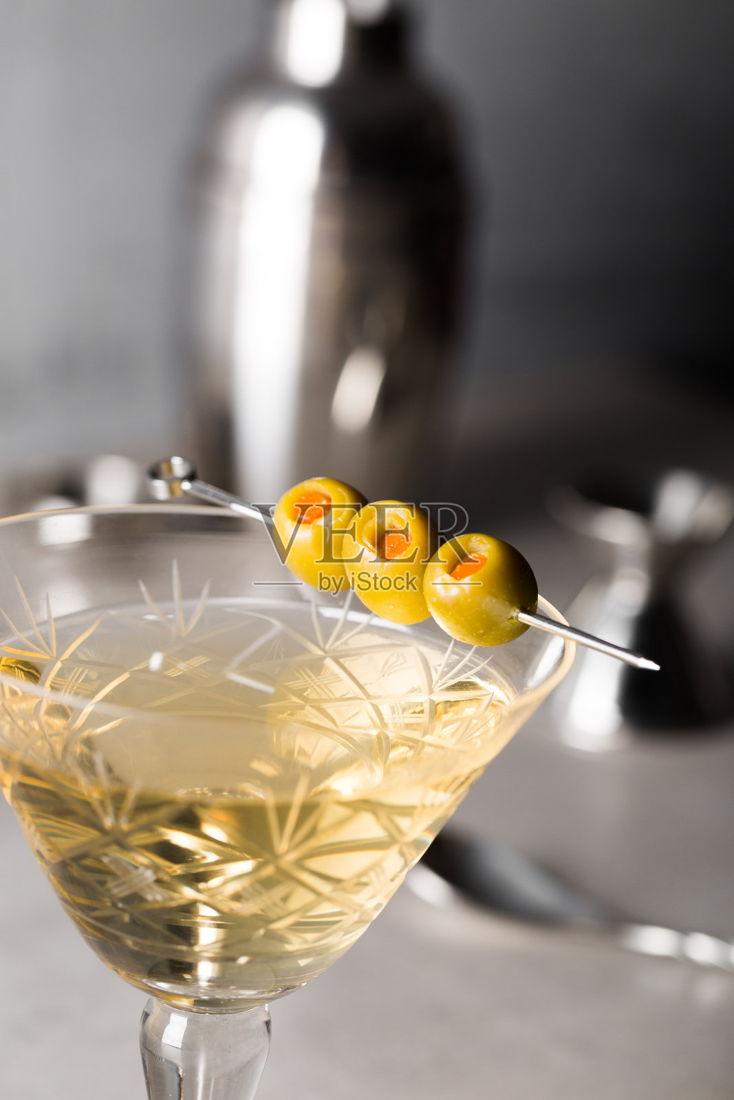 肮脏的马提尼鸡尾酒酒杜松子酒，干苦艾酒和橄榄苦味照片摄影图片
