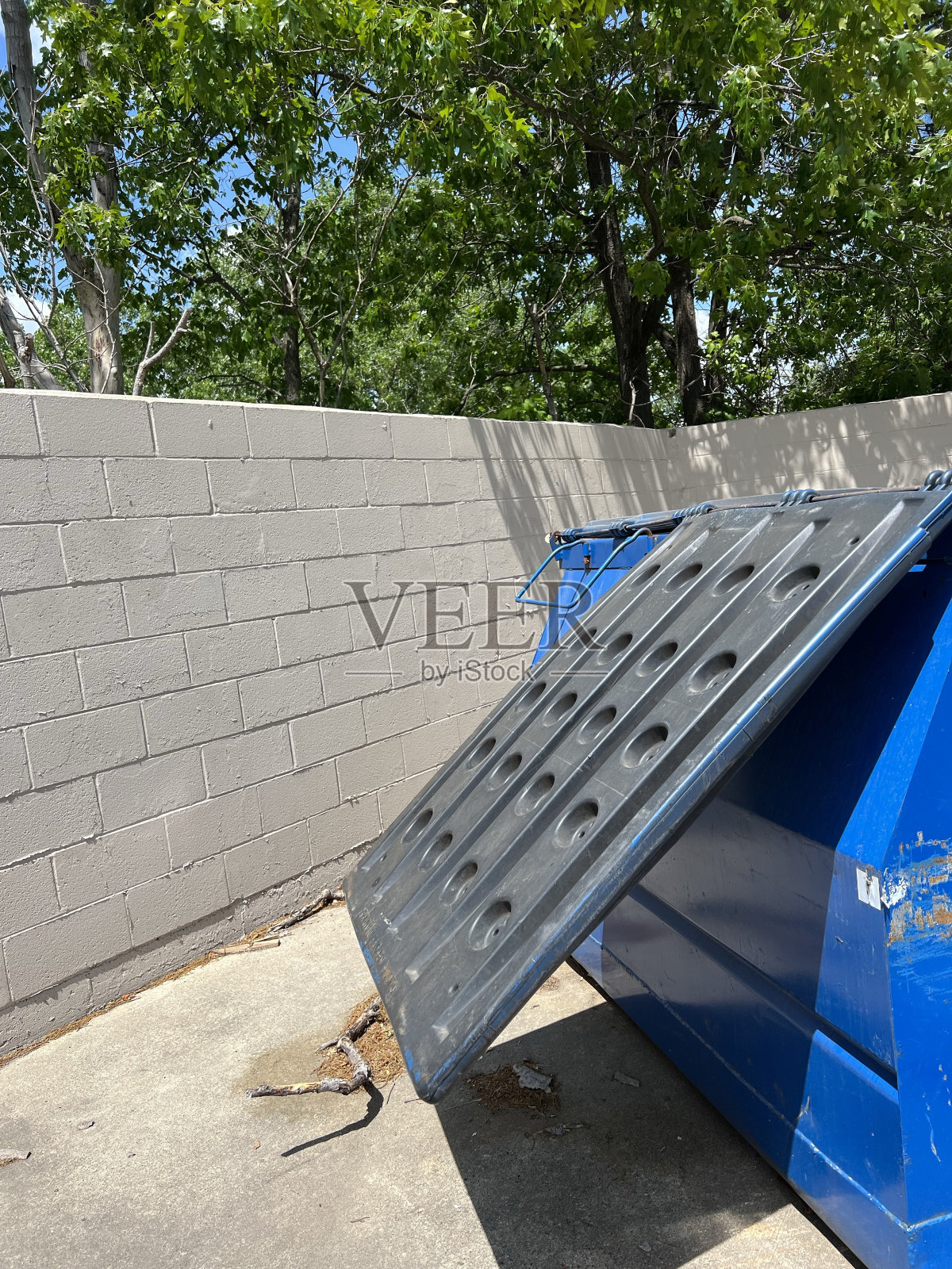 商场后面的蓝色垃圾箱。照片摄影图片