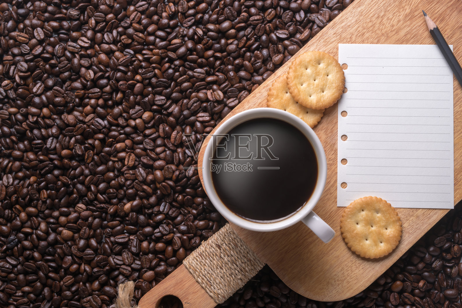 白色杯子里装着咖啡，木头架子上放着笔记和铅笔照片摄影图片