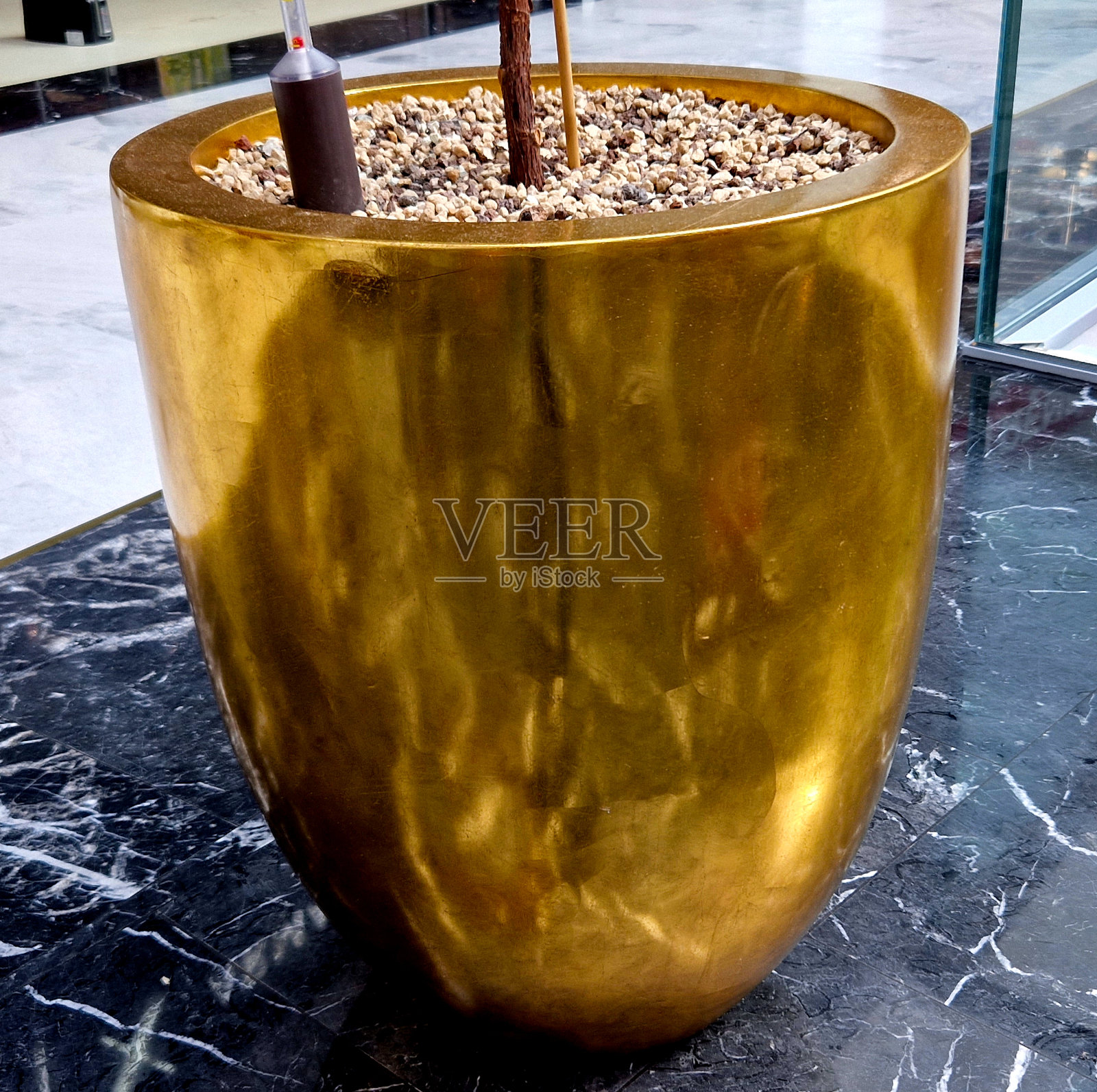 室外餐厅的圆锥形花盆内部为金色。人行道上的桌子。室内盆栽水培。水位指示器，闪亮的金属表面。酒店照片摄影图片