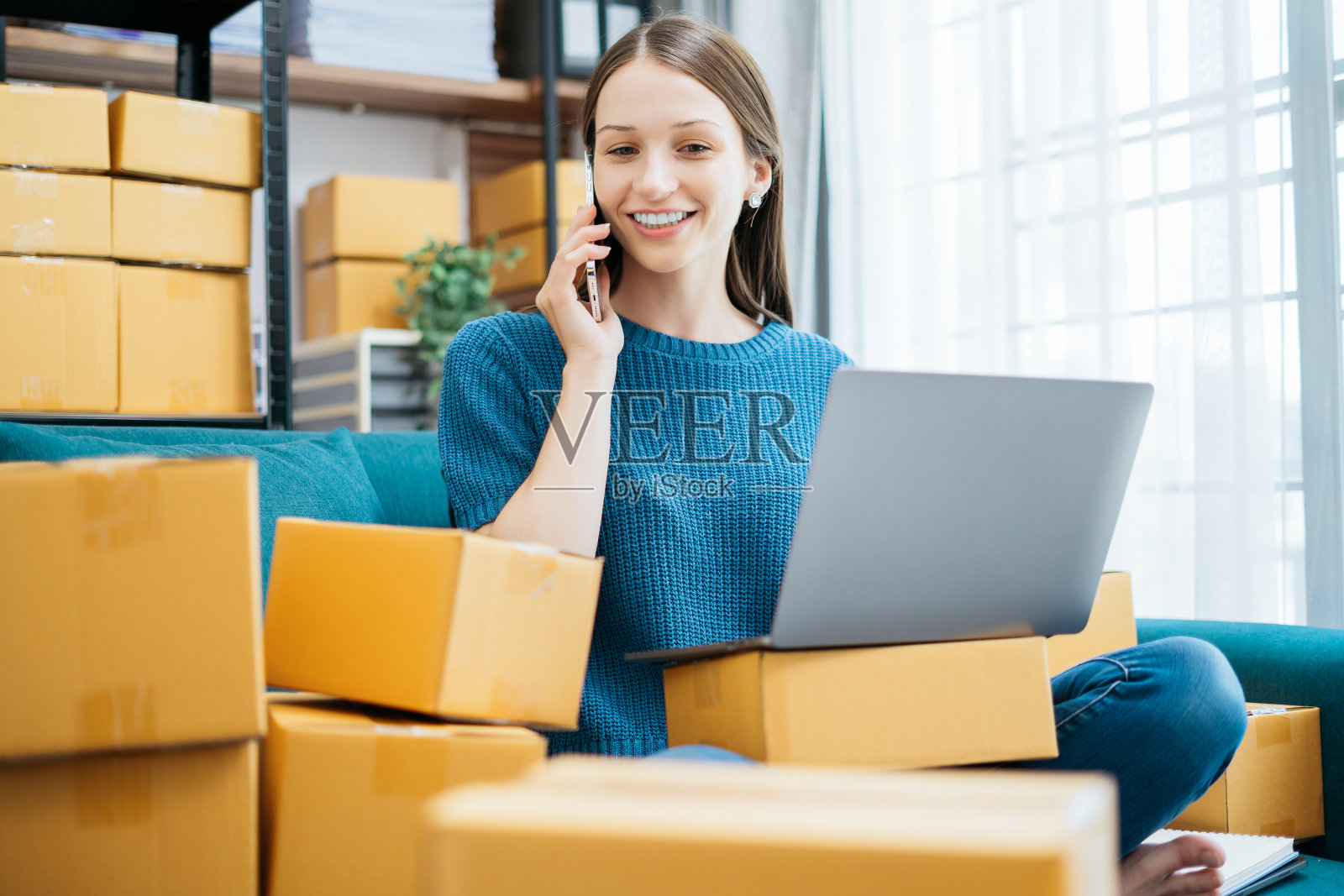 年轻女性用智能手机联系了一位顾客，询问送货地址。照片摄影图片