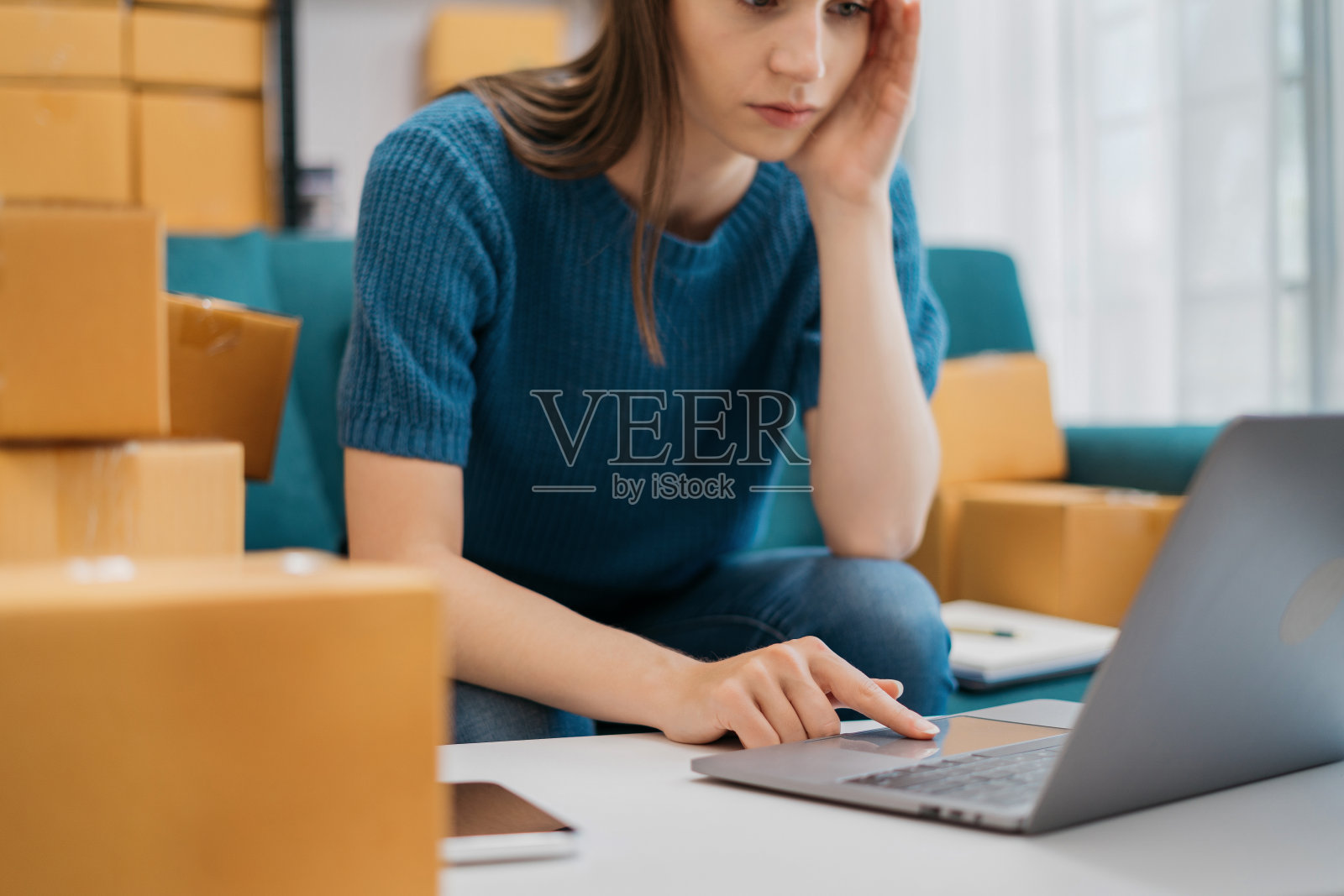 小的网上生意老板，因为家里丢了包裹盒而头疼的女人。照片摄影图片