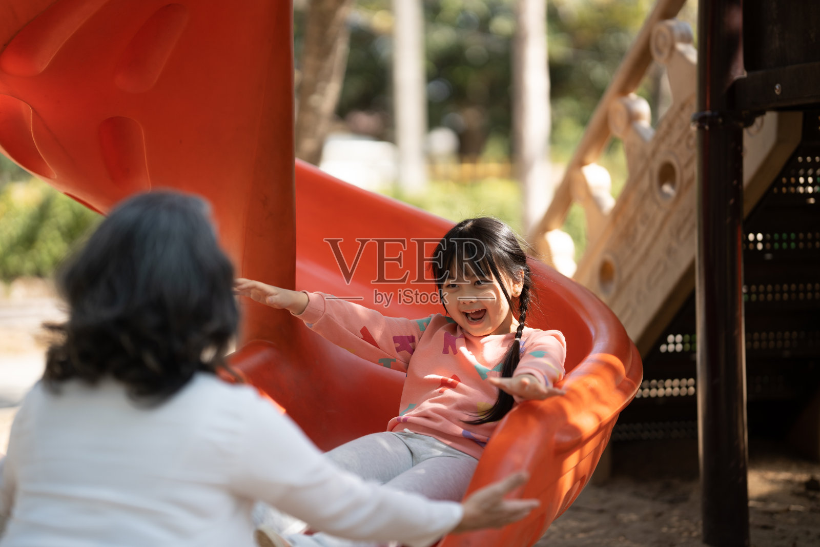 小女孩和她的奶奶在公园的户外操场上玩得很开心照片摄影图片