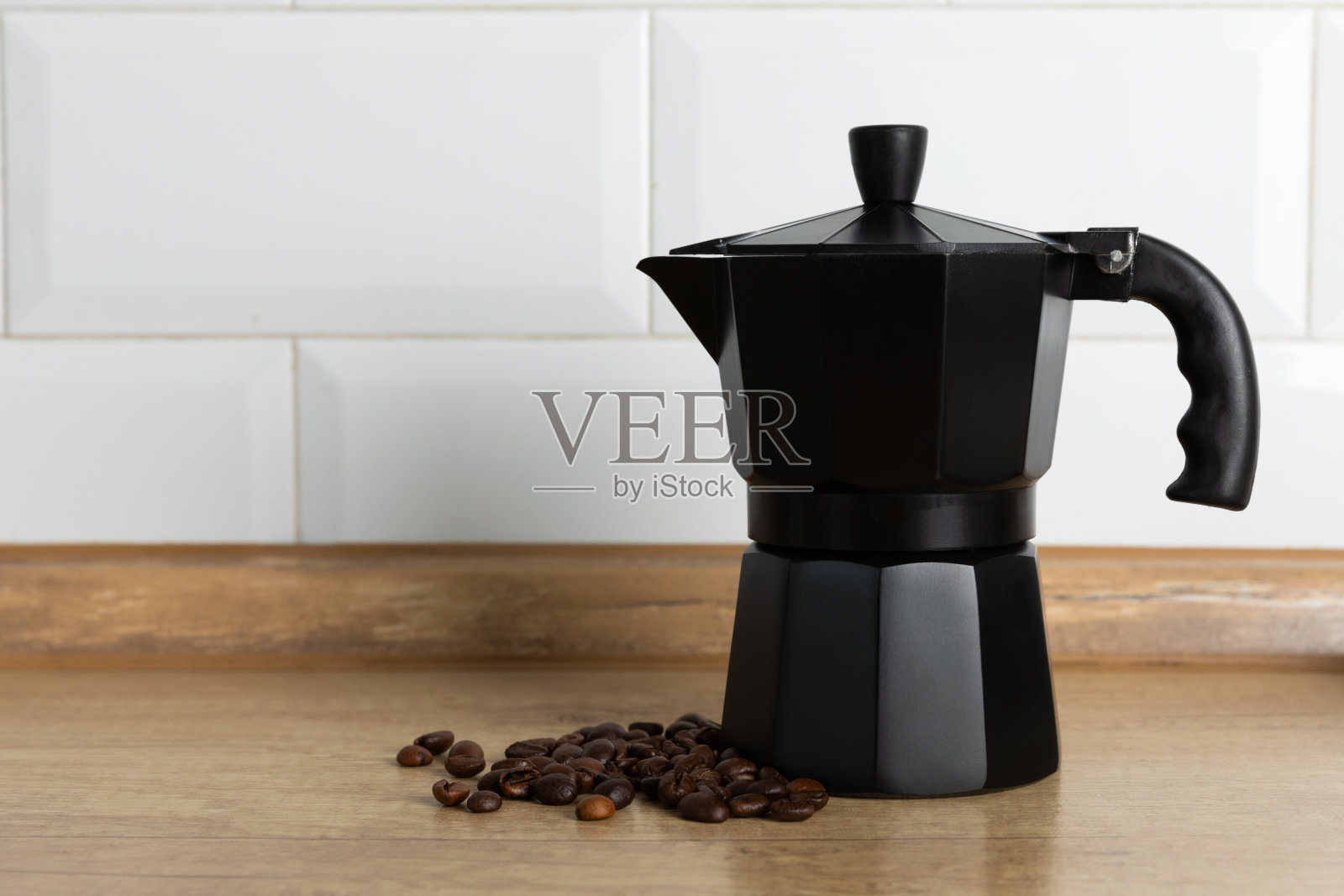 间歇泉咖啡机与咖啡豆在浅色背景。煮咖啡的水壶。制作芳香咖啡的概念。早上好。放文字的地方。副本的空间。照片摄影图片