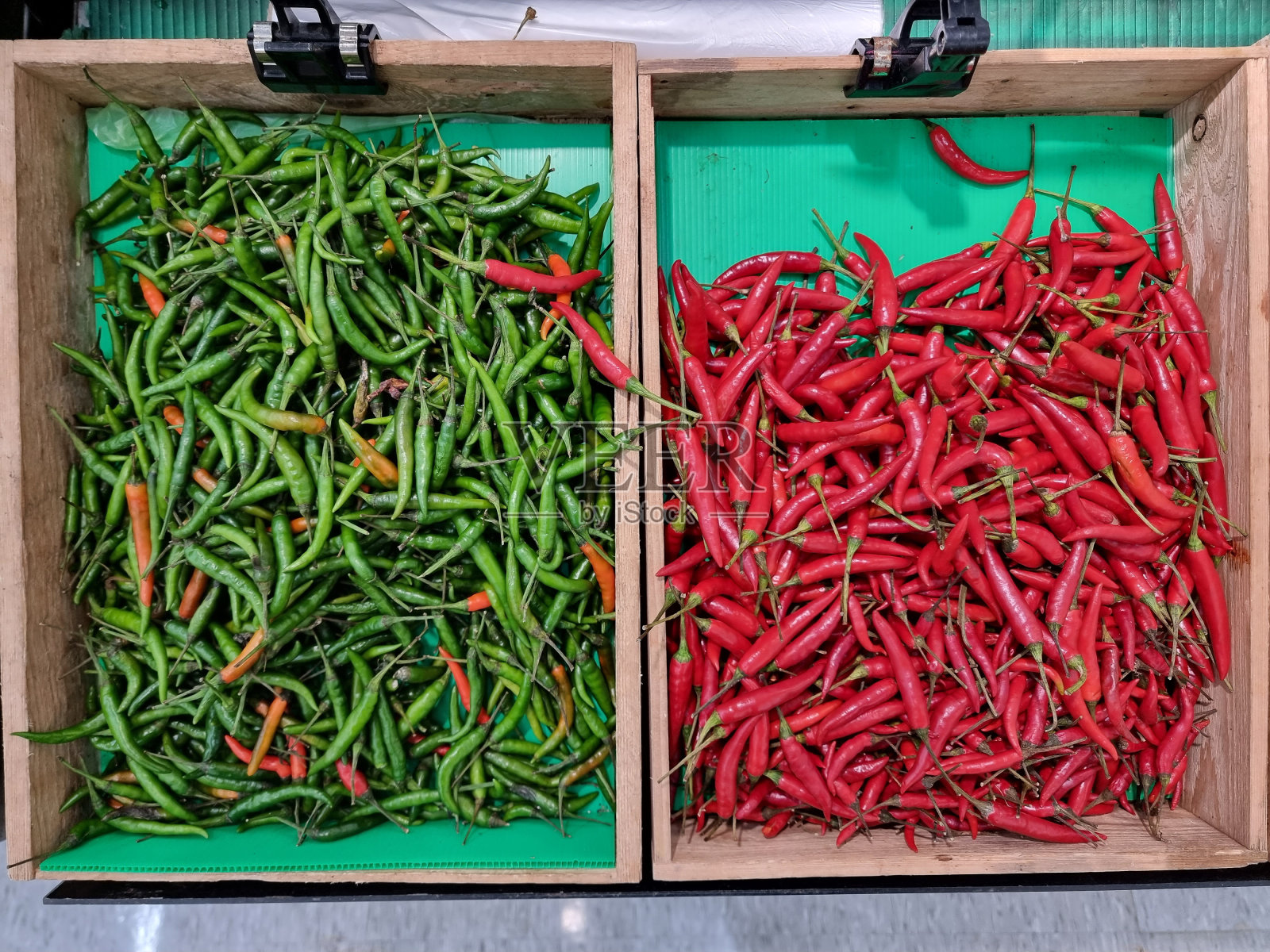 新鲜的青椒和红椒装在木盒子里，在一个新鲜的市场。照片摄影图片