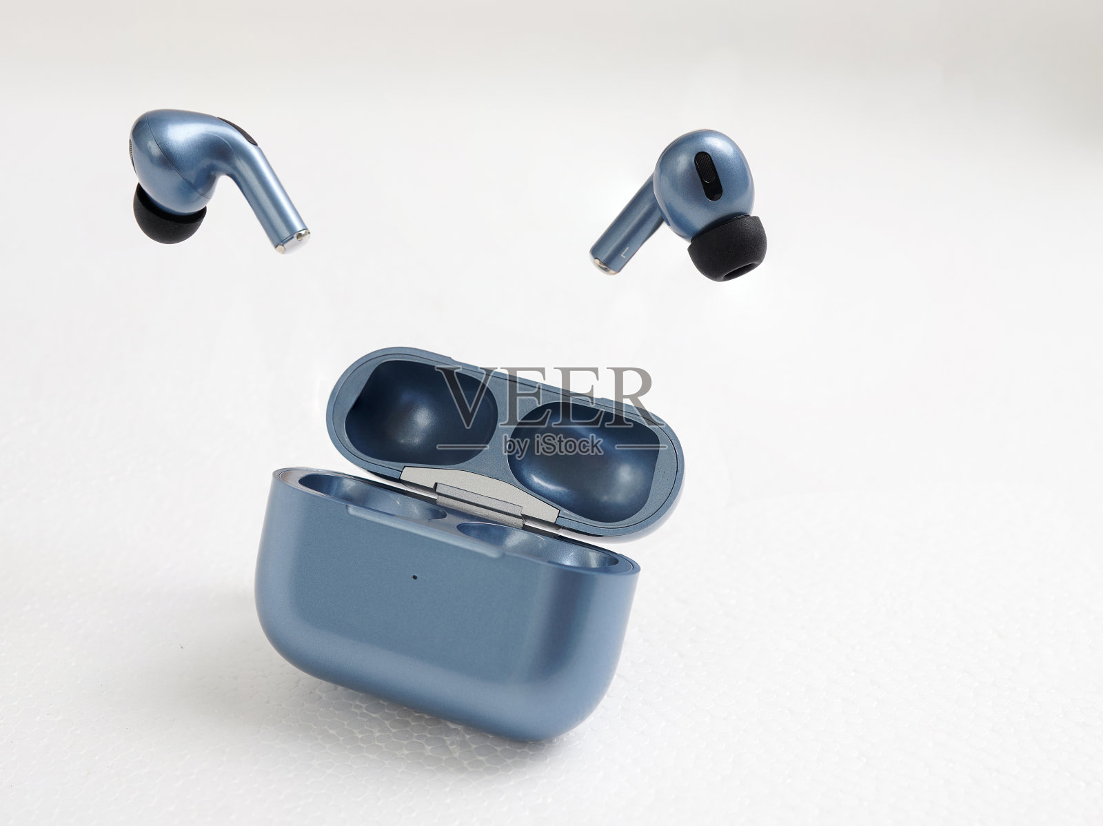 白色背景上的蓝色无线耳机，并留出文字位置。照片摄影图片