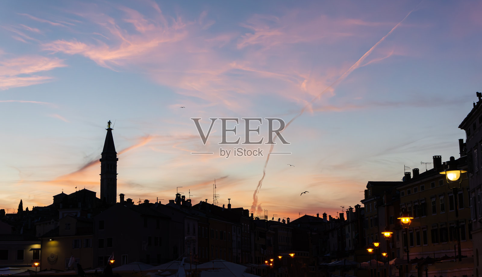 克罗地亚罗维尼中世纪小镇，夕阳的天空和房屋的剪影。照片摄影图片