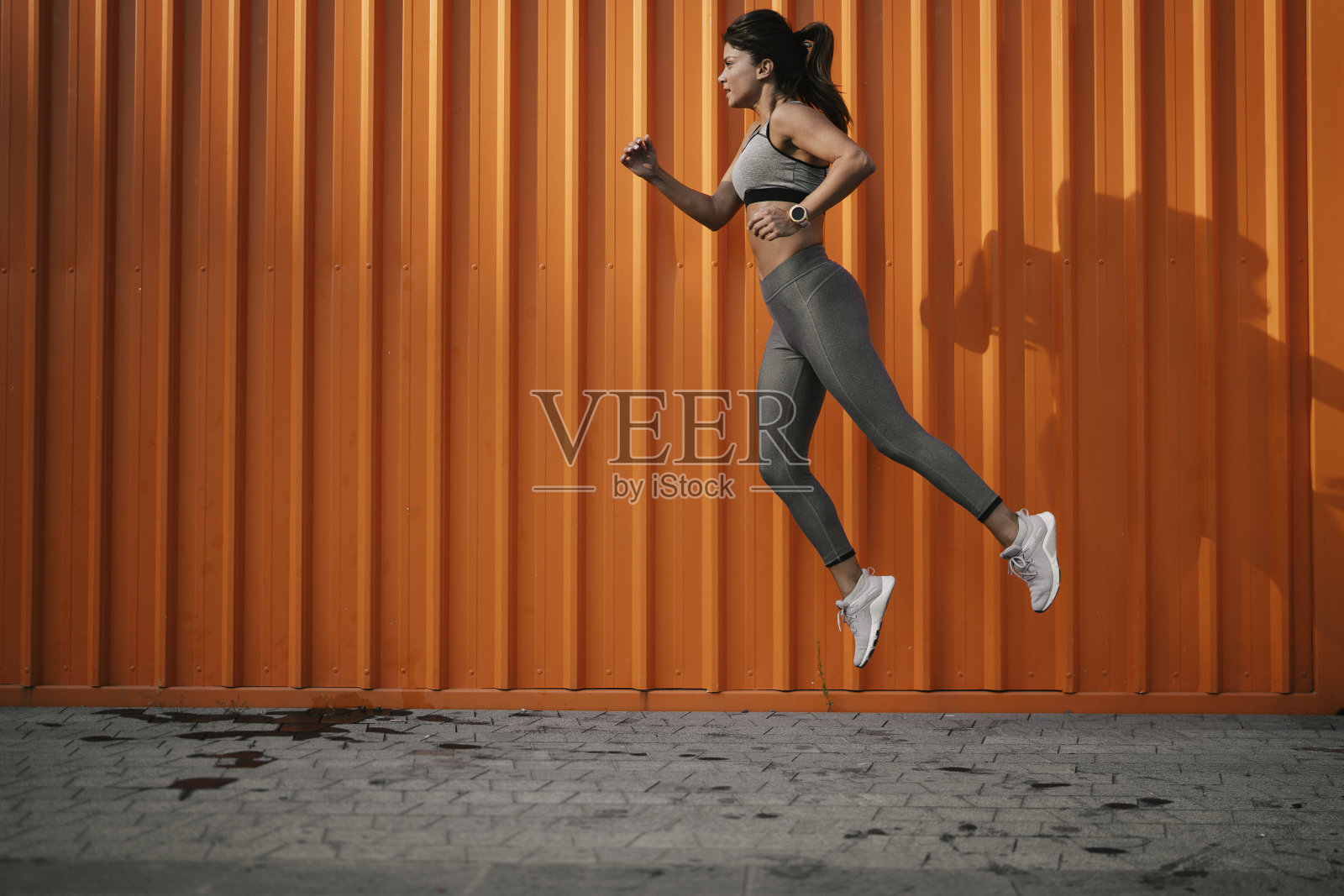 年轻微笑的女子在户外训练。照片摄影图片