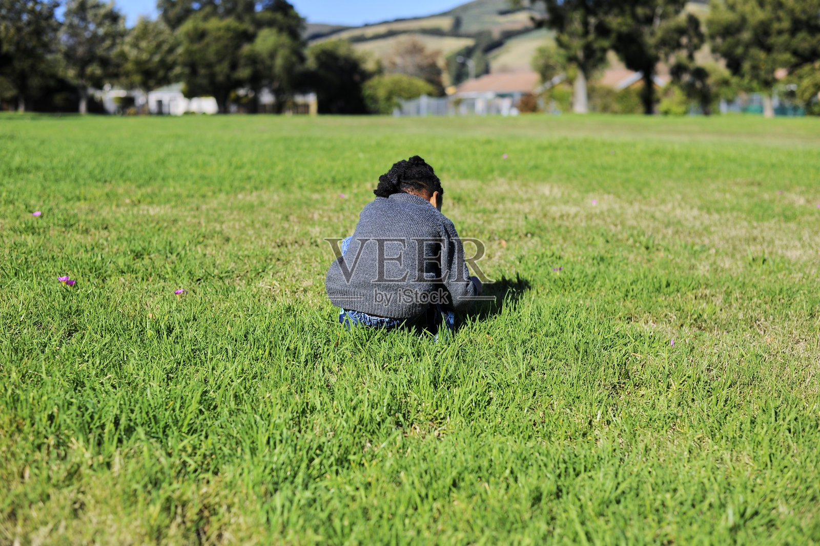 非洲黑人男孩在公园里摘花。照片摄影图片