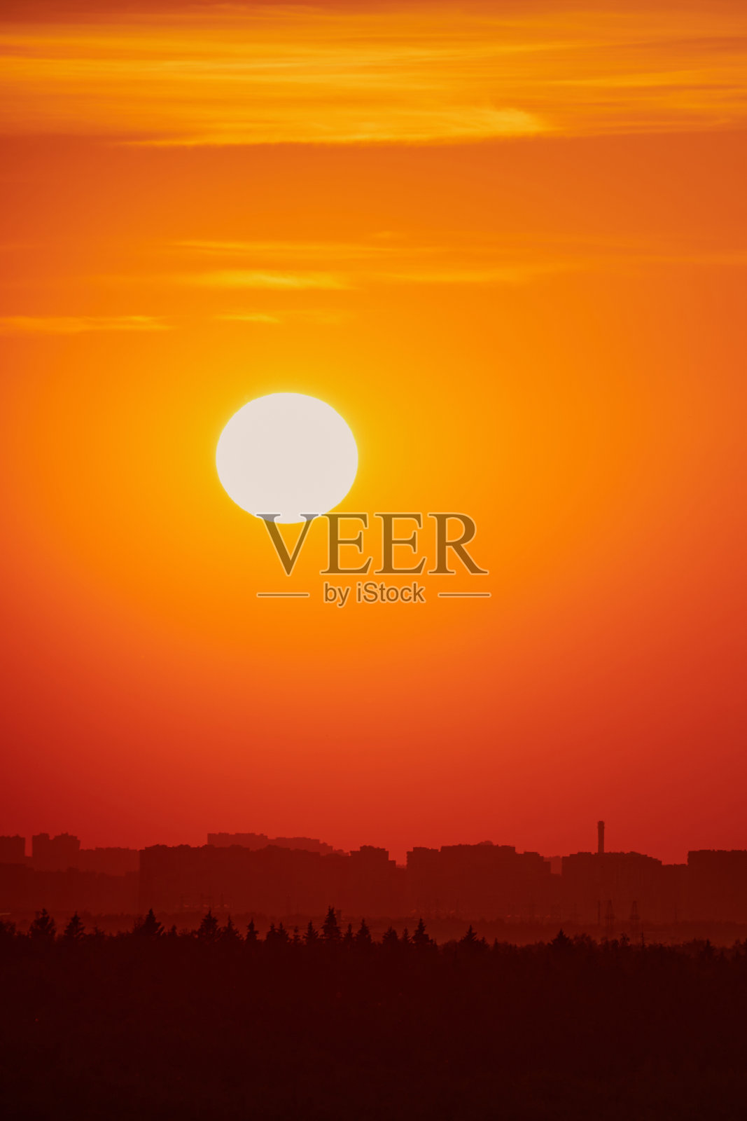 在晴朗的黎明天空上，初升的太阳发出温暖的光芒，这是一幅美丽的景象照片摄影图片