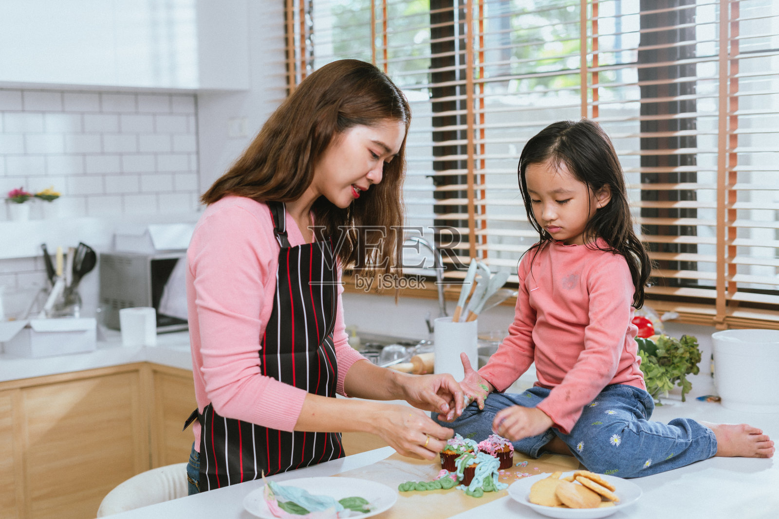 快乐的母亲和女儿在厨房拥抱快乐的时刻照片摄影图片