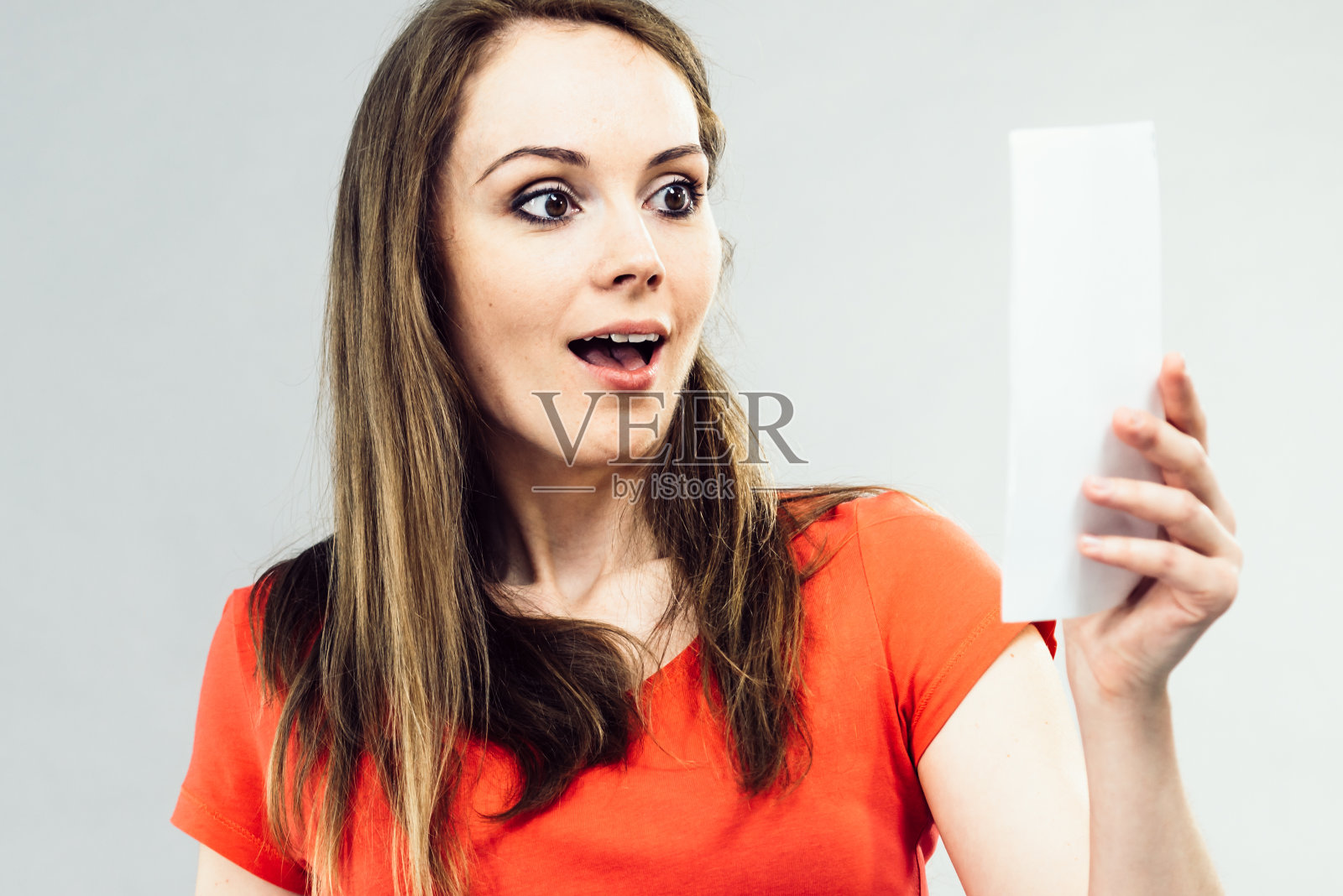 兴奋的女孩看着便条纸。照片摄影图片