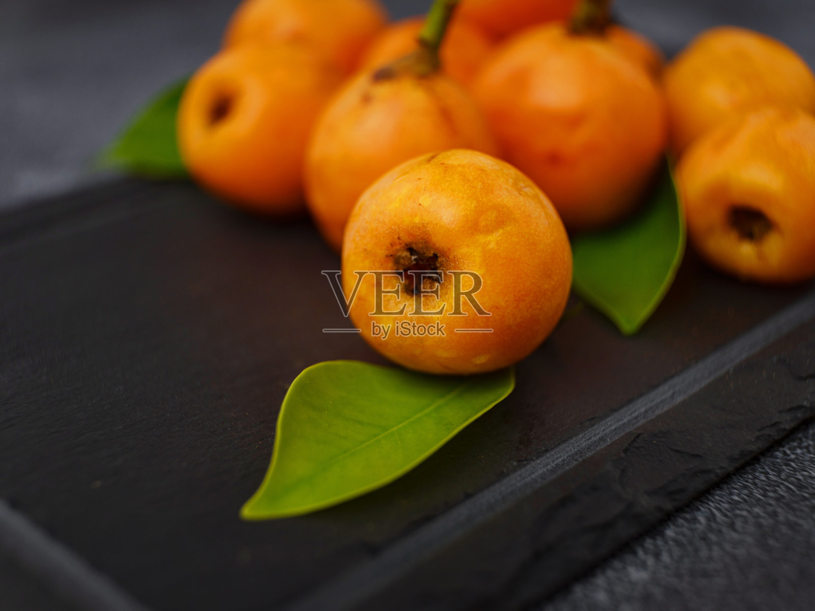 枇杷枸杞果孤立在黑暗的桌子背景照片摄影图片