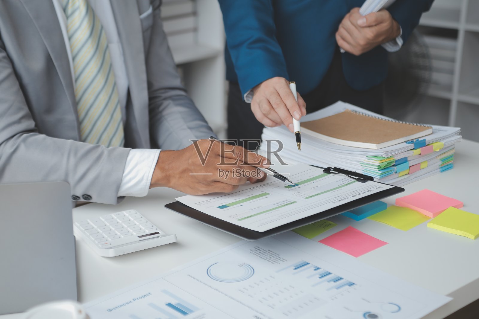 财务分析师在公司会议讨论期间分析了数字平板电脑计划投资项目的商业财务报告，展示了他们成功团队合作的结果。照片摄影图片