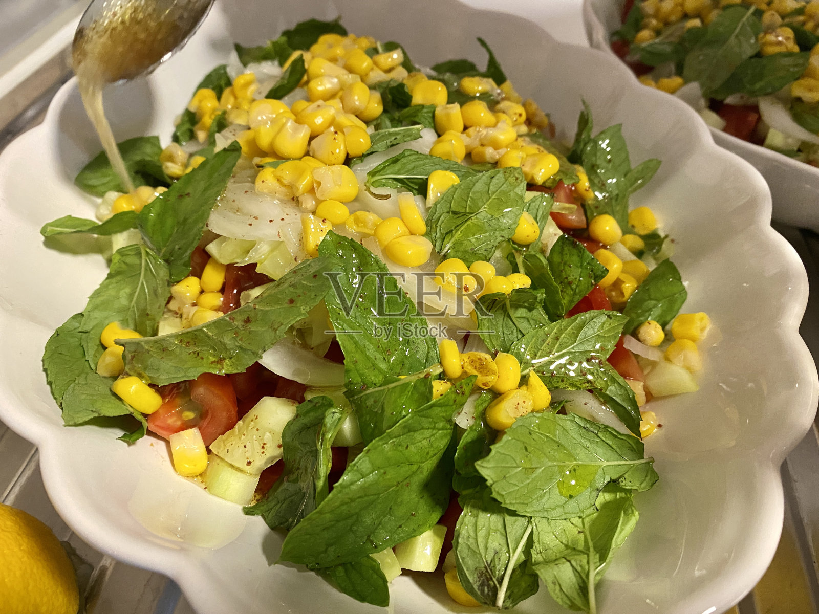 白瓷盘里装着薄荷和玉米沙拉照片摄影图片