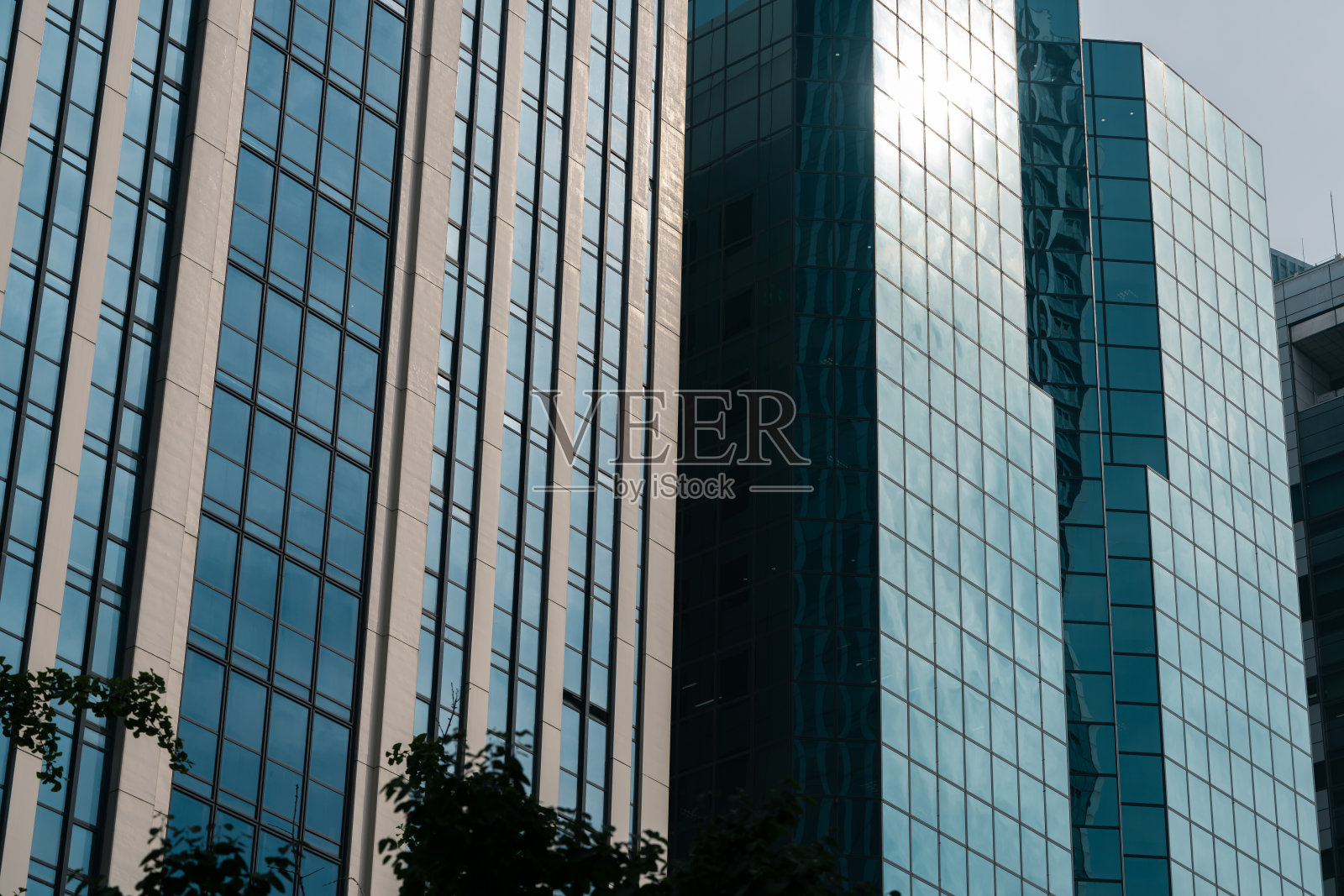 阳光和云彩反射在玻璃和钢铁建造的现代建筑的墙上照片摄影图片