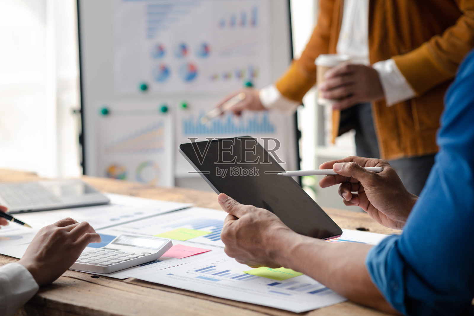 销售部门正在召开月度总结会议，将其提交给部门经理，他们在提交给经理之前核实准备的文件的正确性照片摄影图片