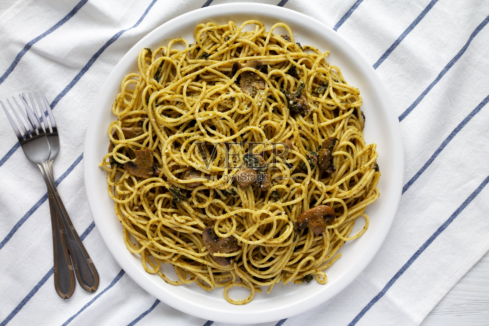 盘子里的自制菠菜蘑菇香蒜酱意大利面，俯视图。平躺，头顶，从上面看。照片摄影图片