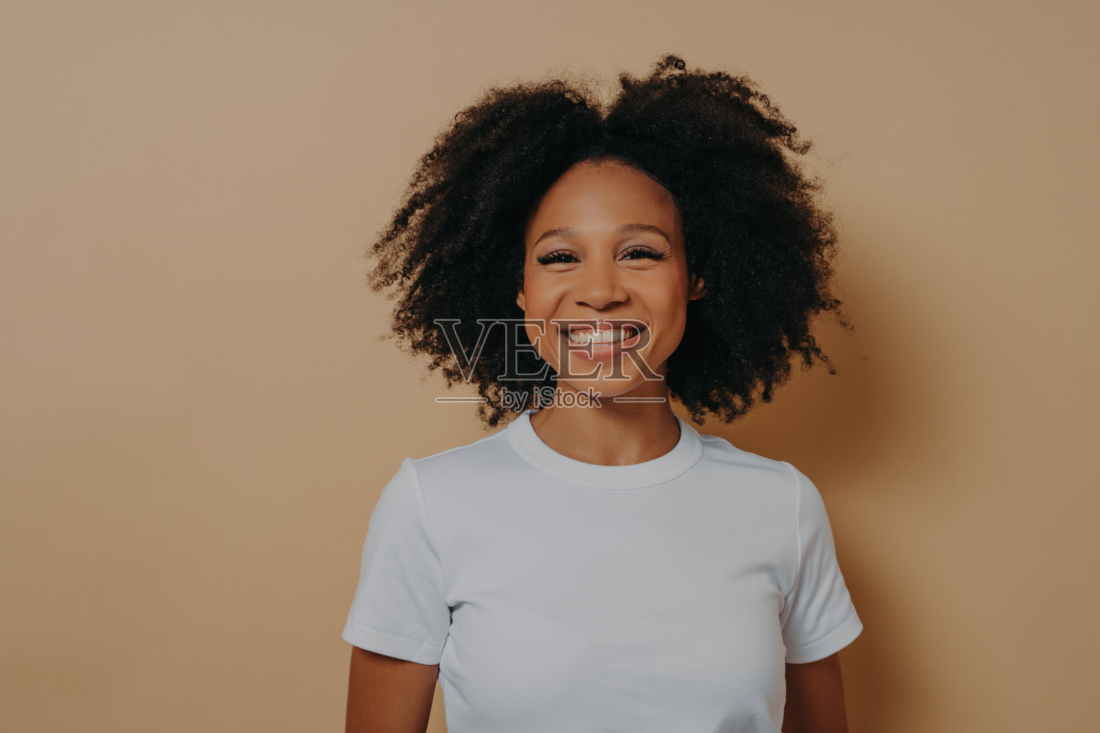 年轻美丽的非洲女性对着镜头微笑，表现出幸福照片摄影图片