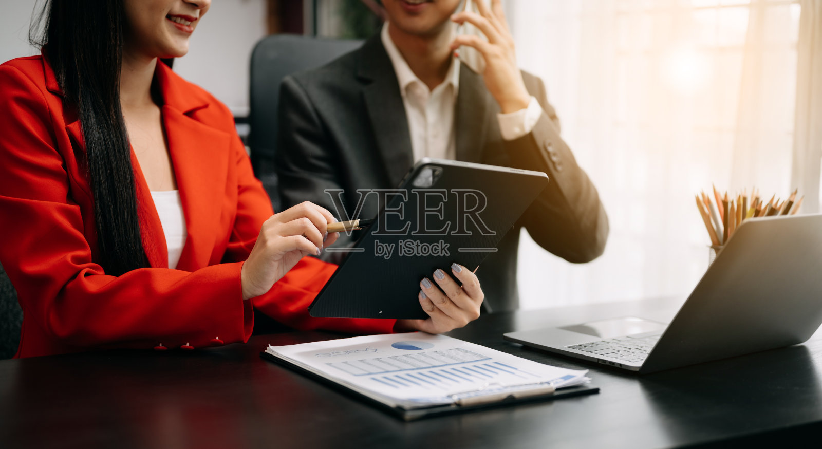 办公桌上的商务文件用智能手机和计算器数码平板电脑，用社交网络图和两个同事在办公室讨论数据工作照片摄影图片