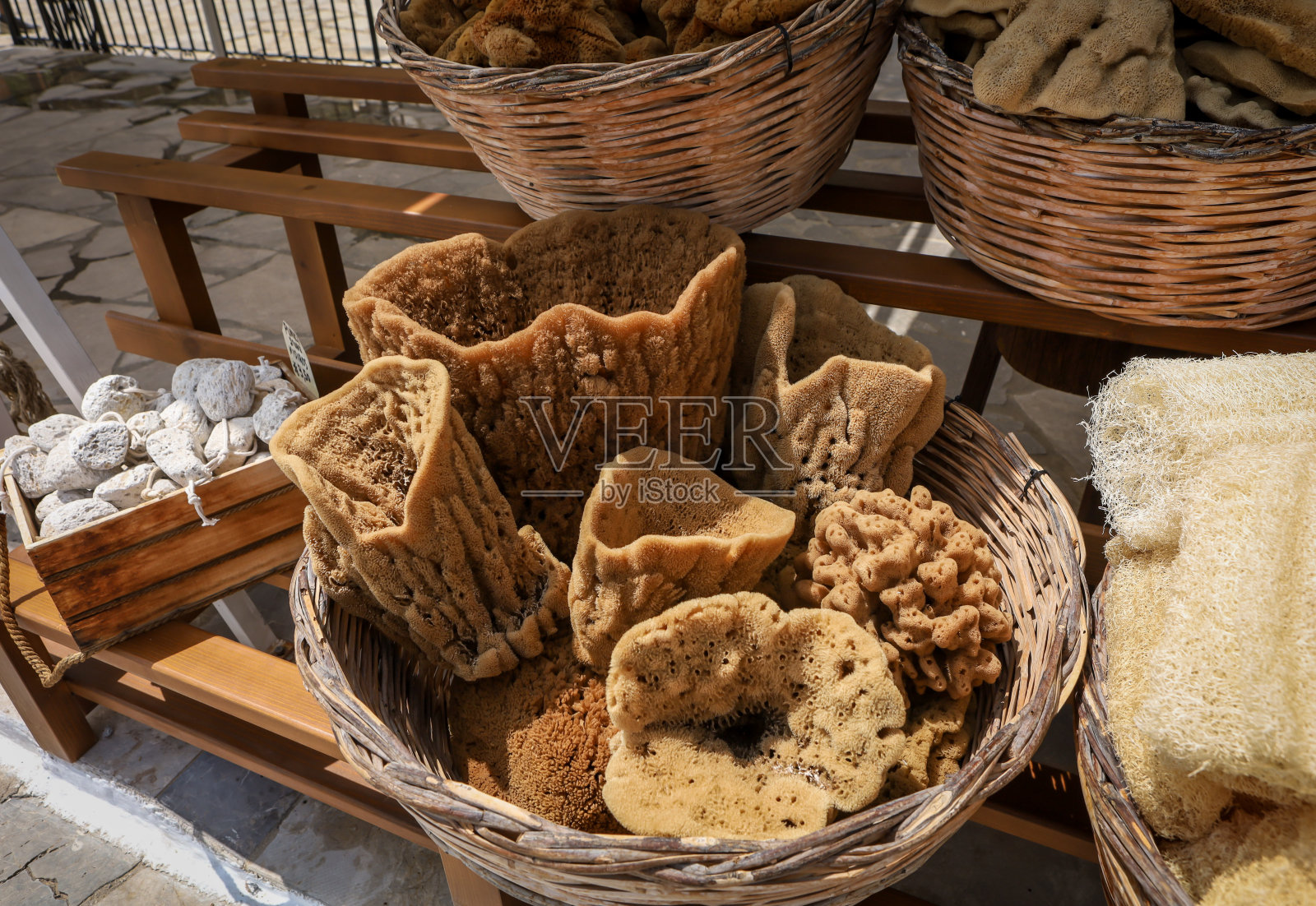 希腊礼品店里装满天然海绵的柳条篮子。照片摄影图片