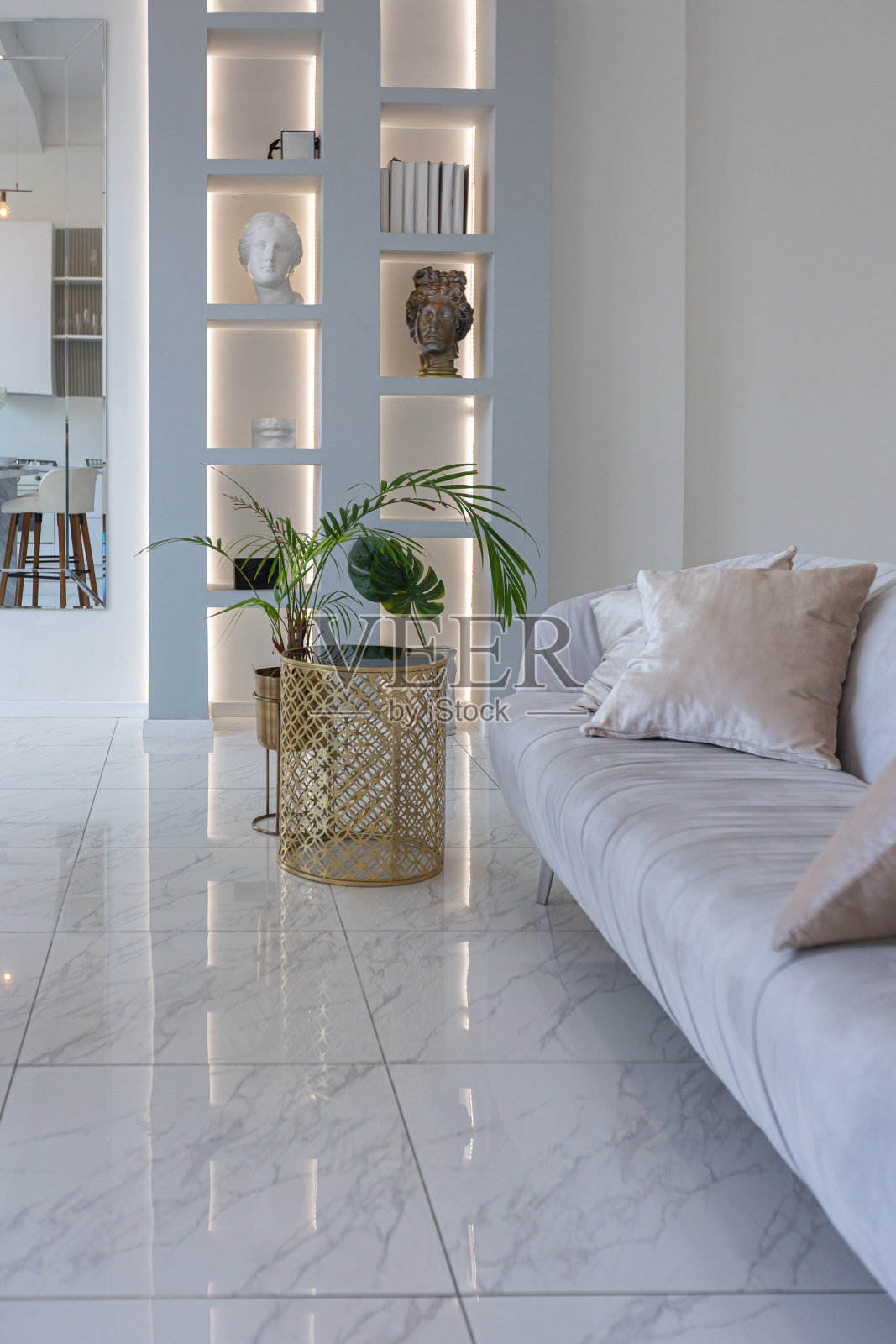 简约的光优雅的豪华设计，现代宽敞的一室公寓，厨房区，卧室和沙发后面的巨大镜子。地板上铺着瓷砖，天花板很高。照片摄影图片