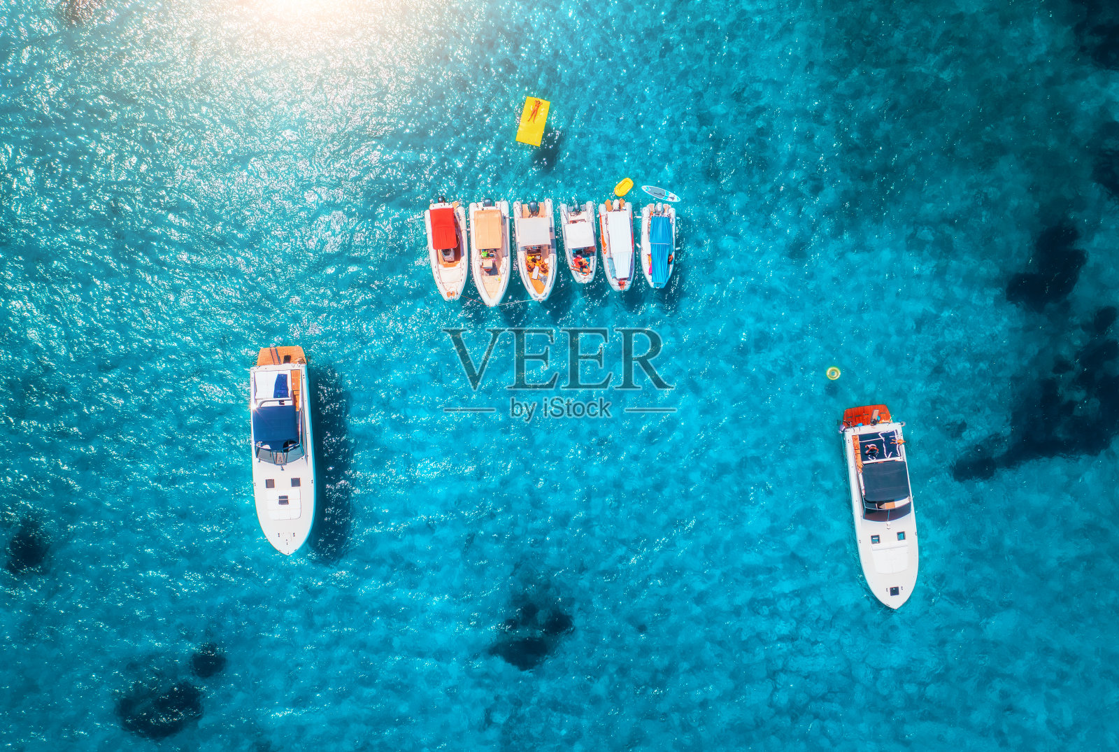 夏日日出时豪华游艇和船只的鸟瞰图。去意大利撒丁岛旅游。无人机俯瞰摩托艇、游艇、海洋泻湖、透明蔚蓝的海水。海景。俯视图照片摄影图片