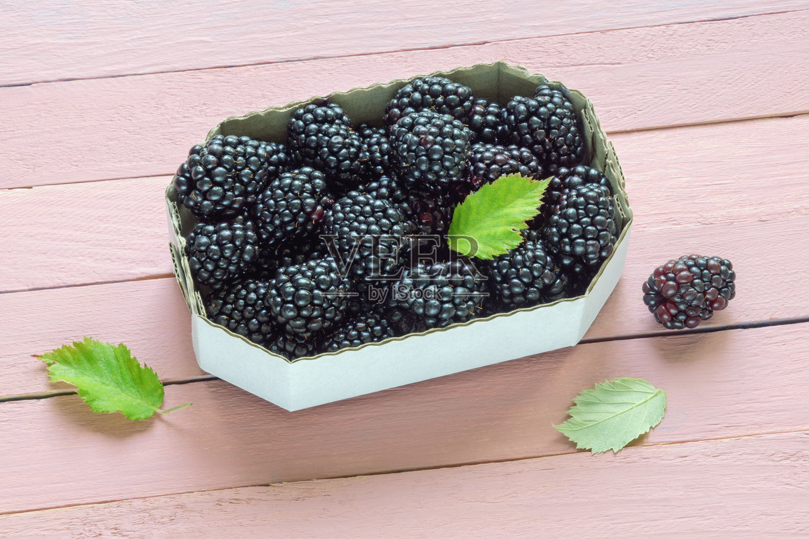 市场上的黑莓。新鲜成熟的黑莓装在纸板箱里，放在质朴的桌子上。本空间照片摄影图片