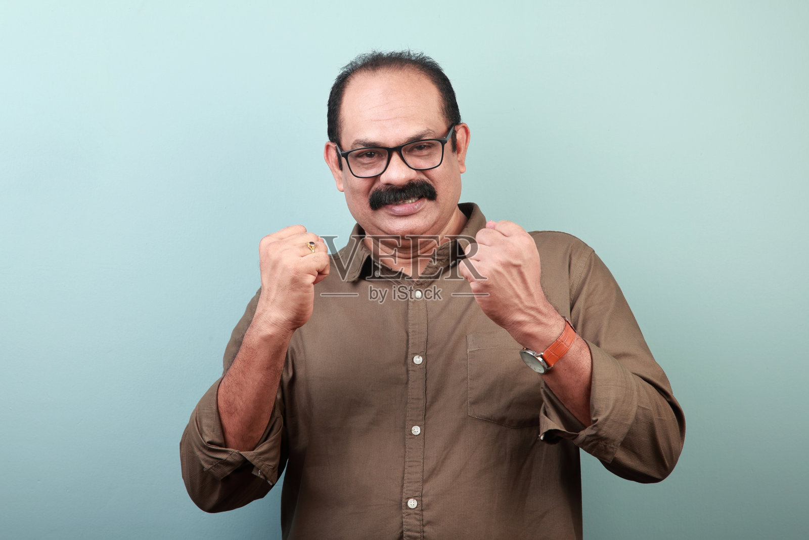 一名印度裔中年男子的肖像，双手做着欢呼的手势照片摄影图片