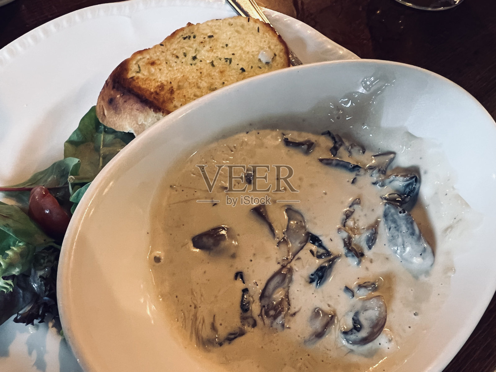 大蒜蘑菇汤配一片热大蒜面包照片摄影图片