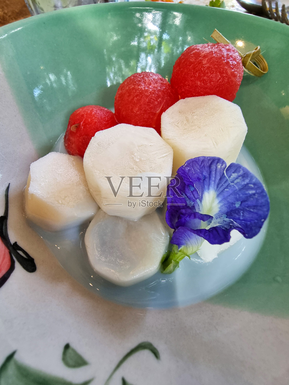 甜蜜的自制甜点圆红西瓜球和椰子冰淇淋装饰蝴蝶豌豆花照片摄影图片