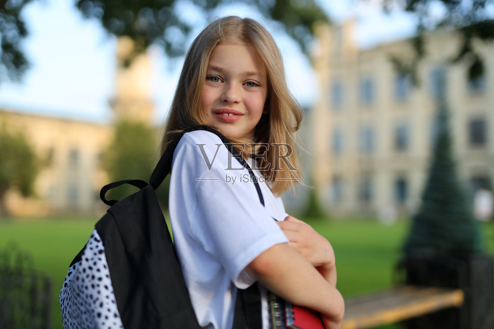 背着双肩包的可爱女学生。照片摄影图片