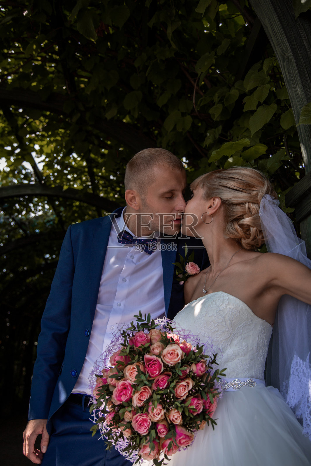 一对新婚夫妇穿着以自然为背景的婚纱。夏天在公园举行婚礼。照片摄影图片